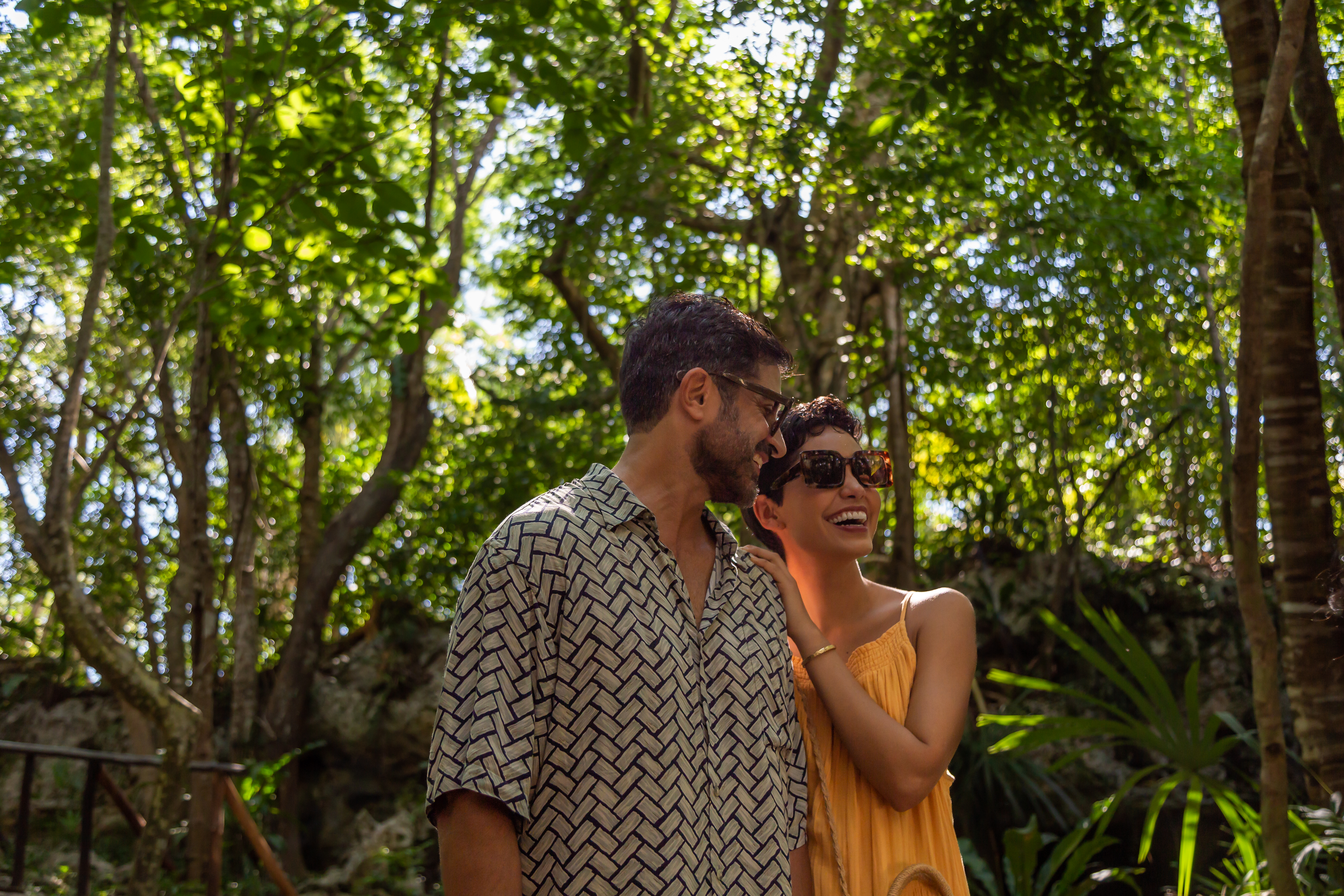 a man and woman standing in the woods