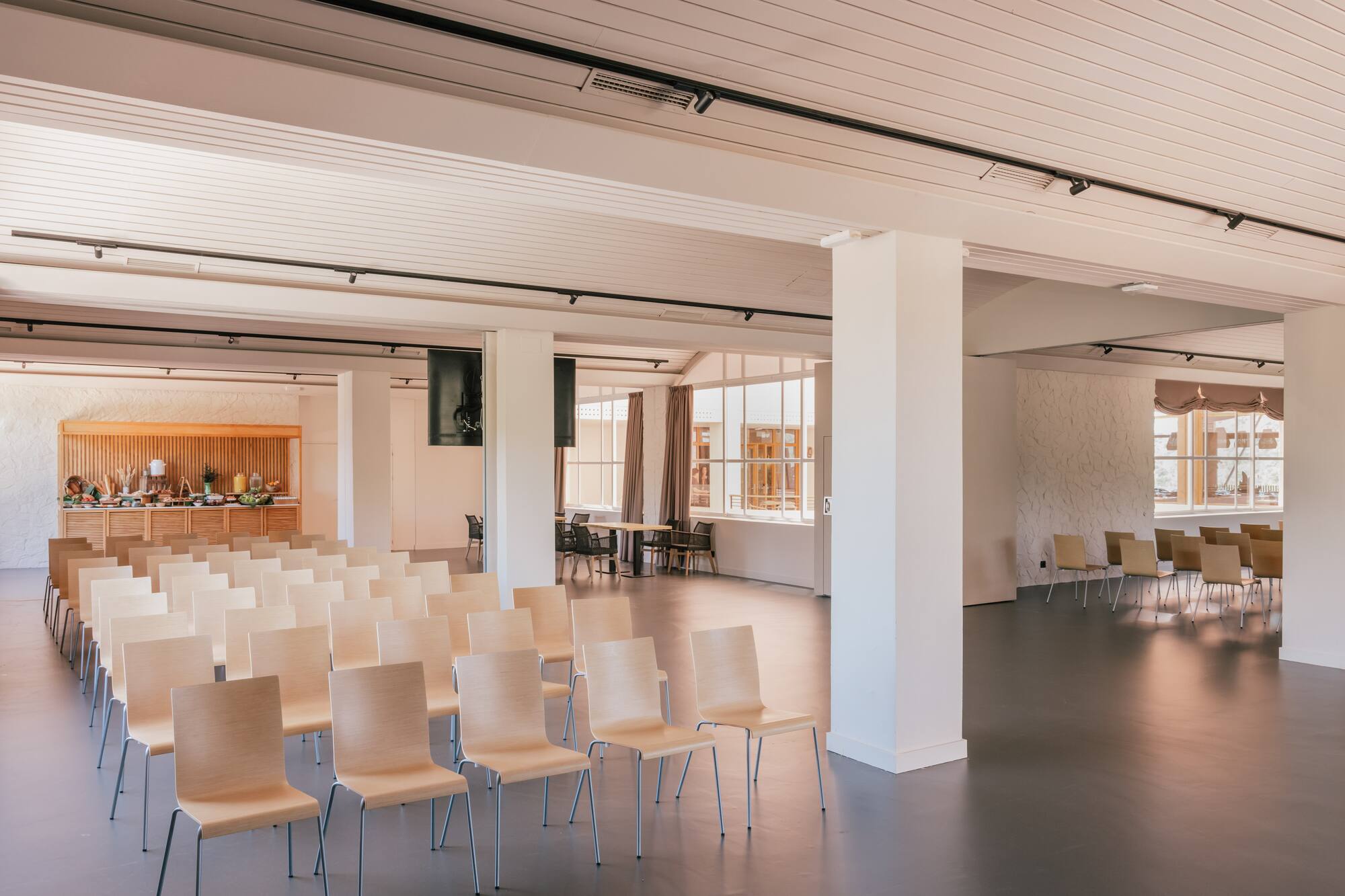 Bright event venue with theater seating, buffet, and large windows.