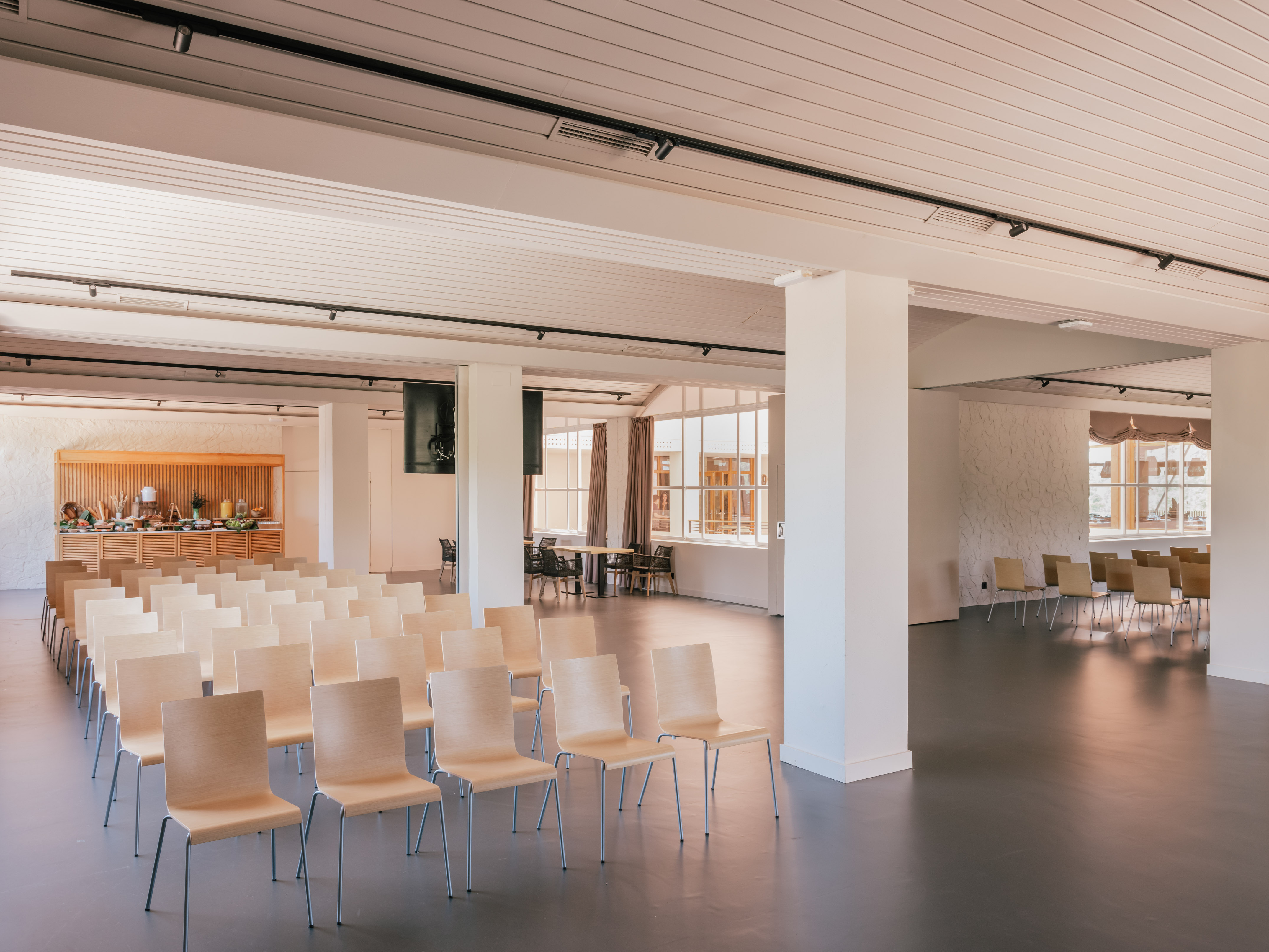 Bright event venue with theater seating, buffet, and large windows.