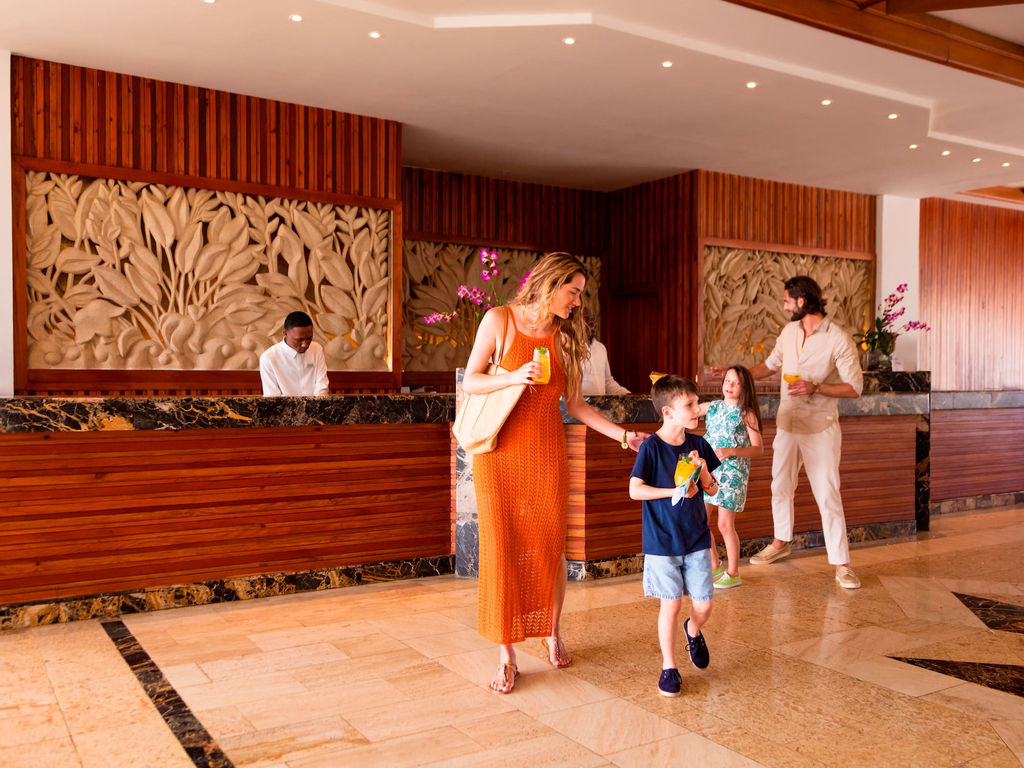a woman and a boy walking in a lobby