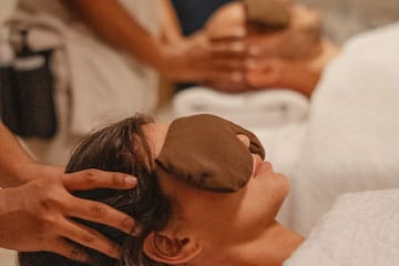 a woman lying down with a mask on her face