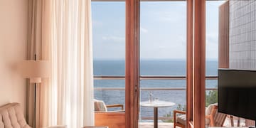 a room with a view of the ocean from the balcony