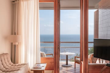 a room with a view of the ocean from the balcony