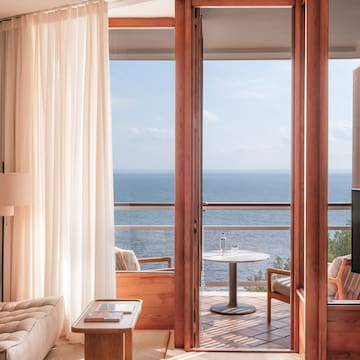 a room with a view of the ocean from the balcony