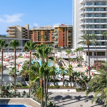 a pool and palm trees in front of buildings