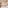Minimalist hotel bedroom with wood storage, white bed, and in-room safe.