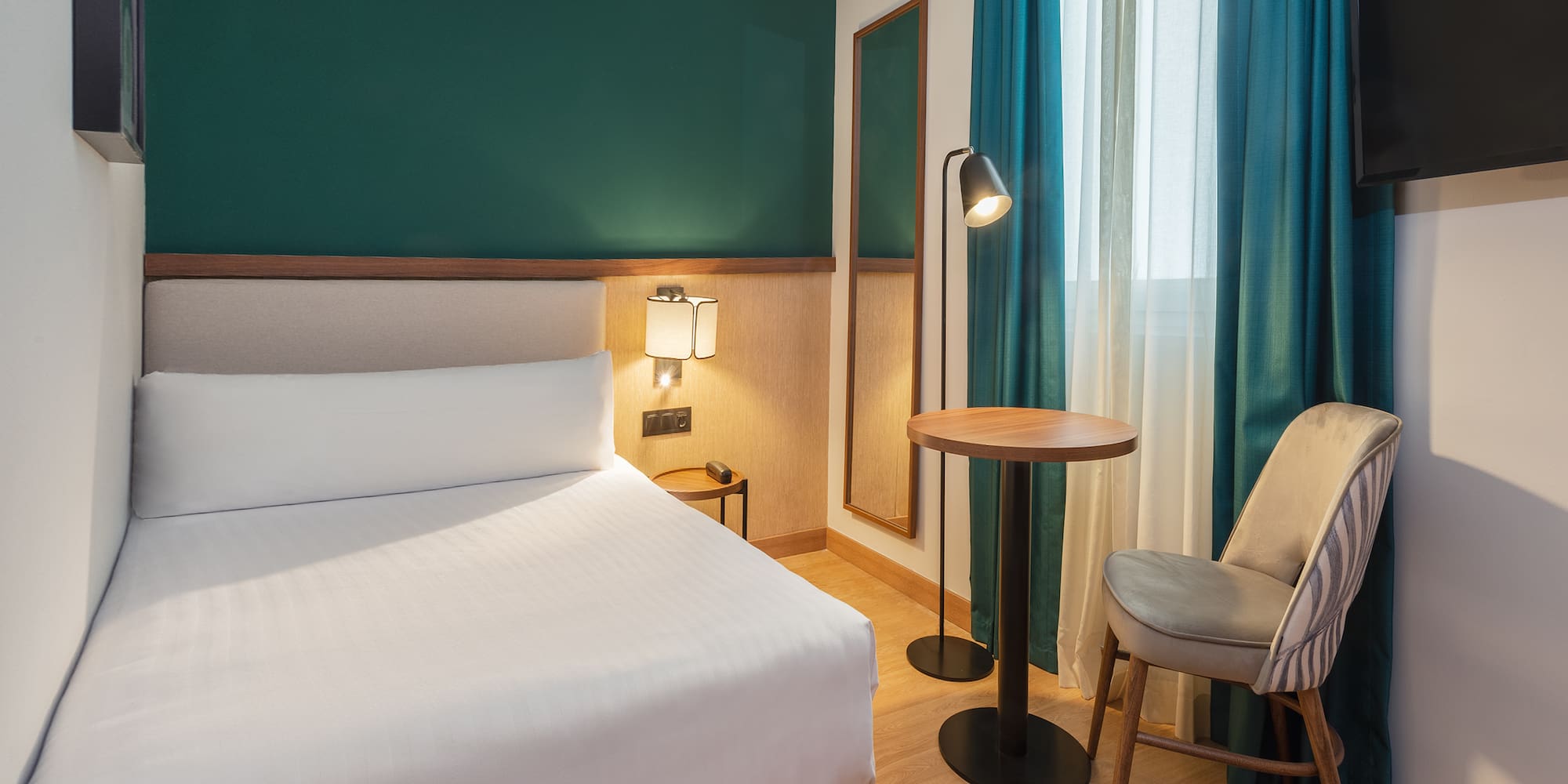 a room with a bed and a table and chairs