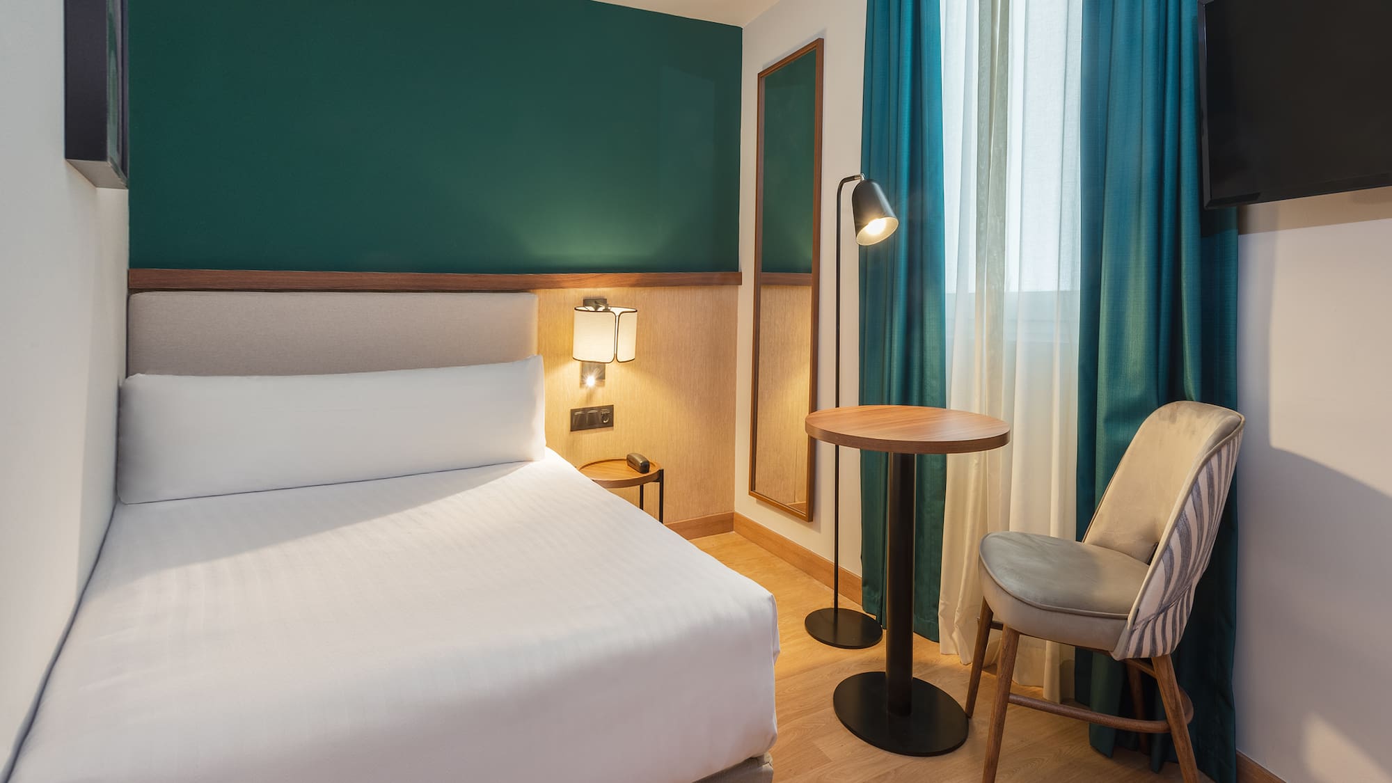 a room with a bed and a table and chairs