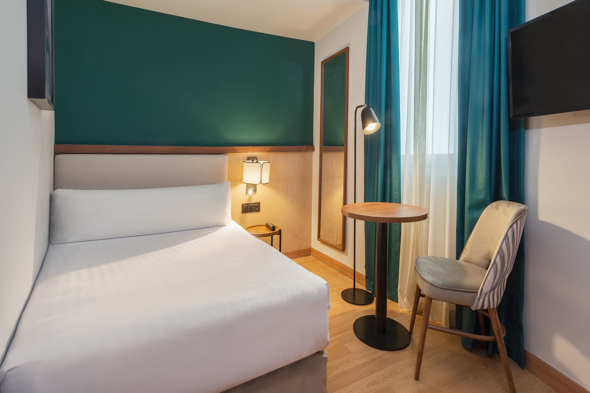 a room with a bed and a table and chairs