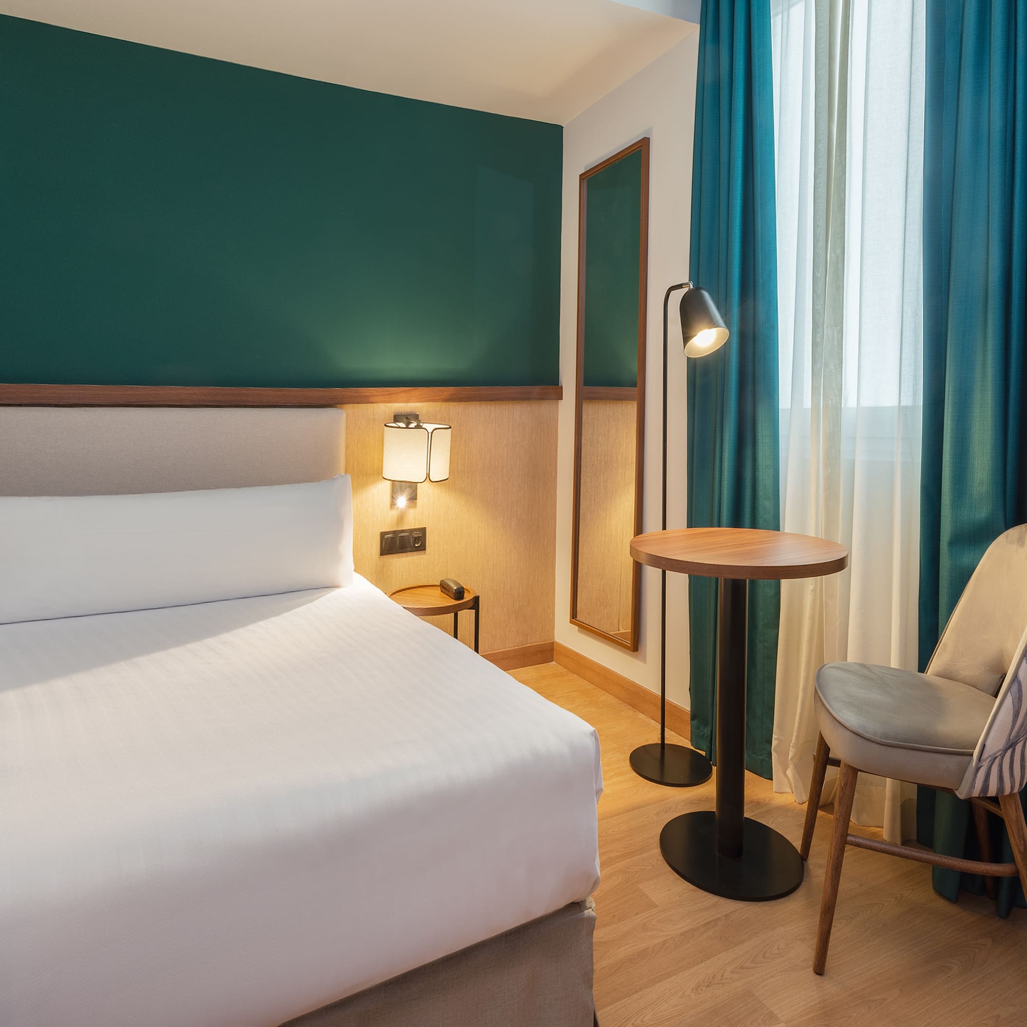 a room with a bed and a table and chairs