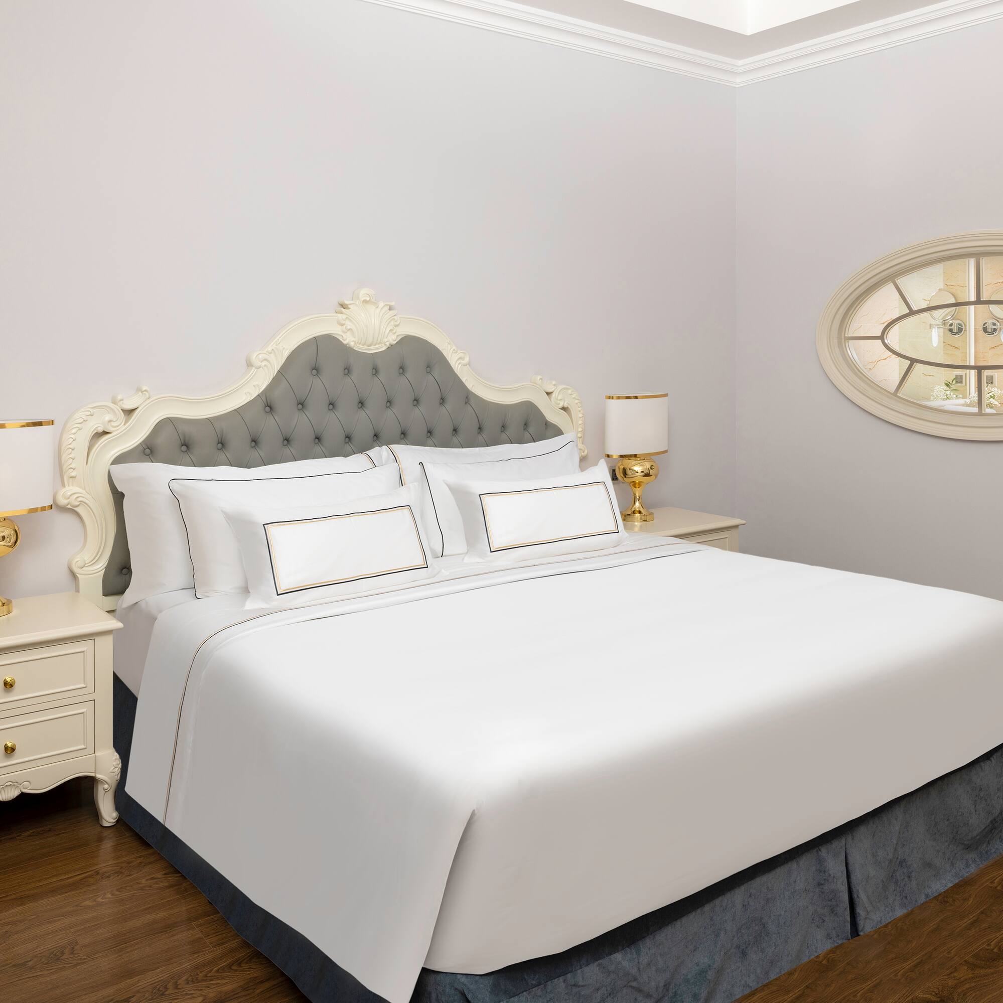 a bed with white sheets and a lamp on the side