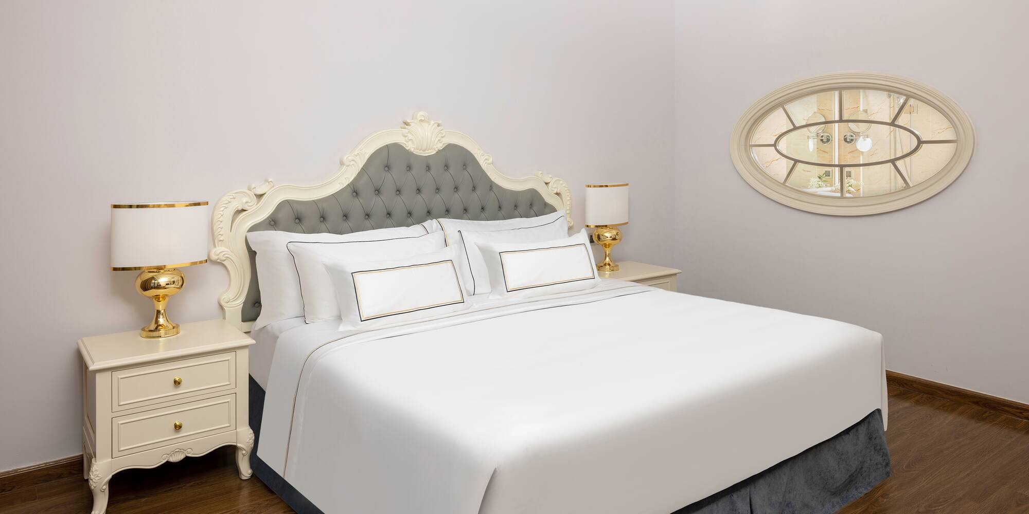 uma cama com lençóis brancos e uma lâmpada ao lado