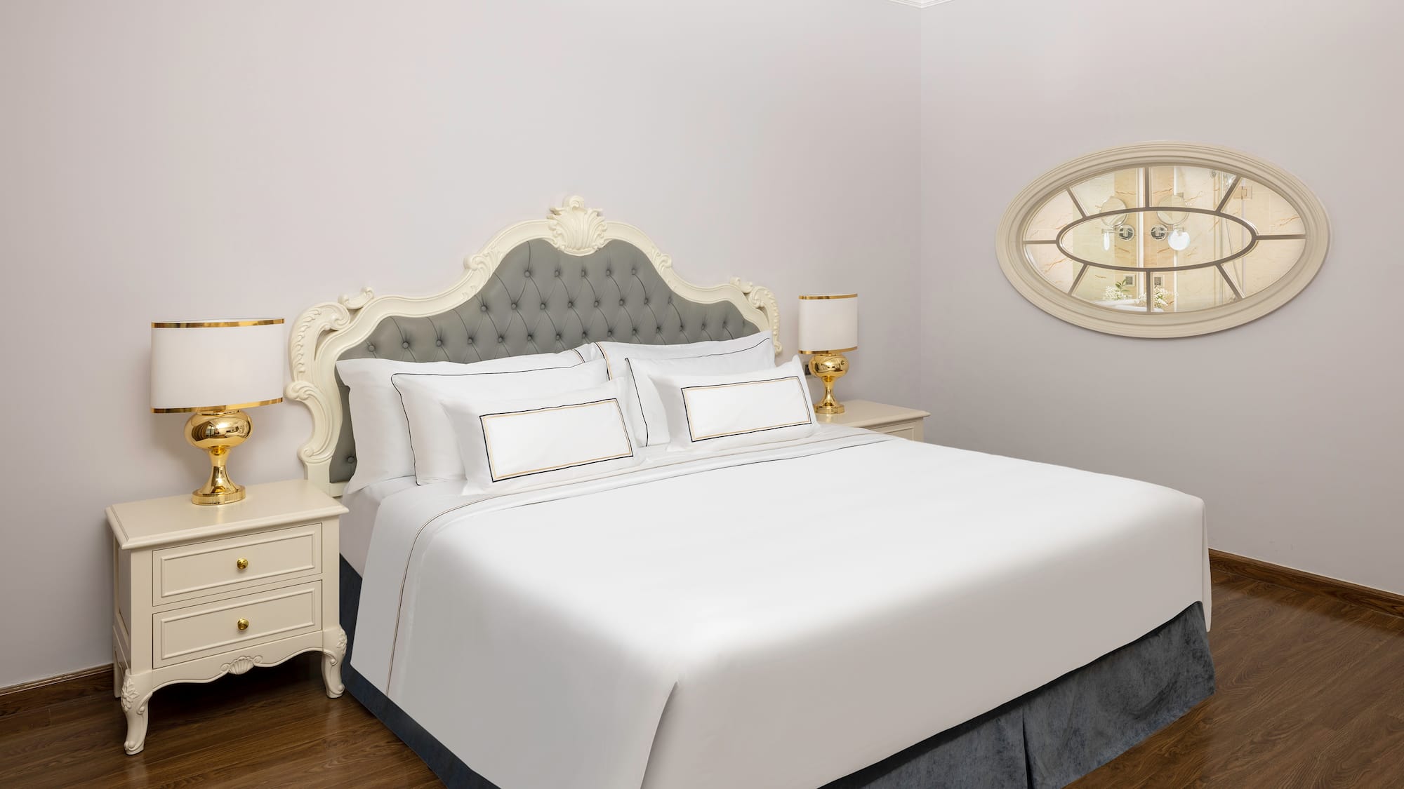 uma cama com lençóis brancos e uma lâmpada ao lado