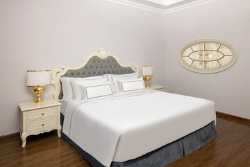 a bed with white sheets and a lamp on the side