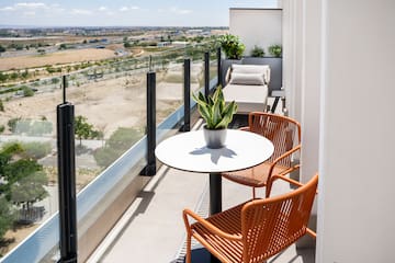 a balcony with chairs and a table