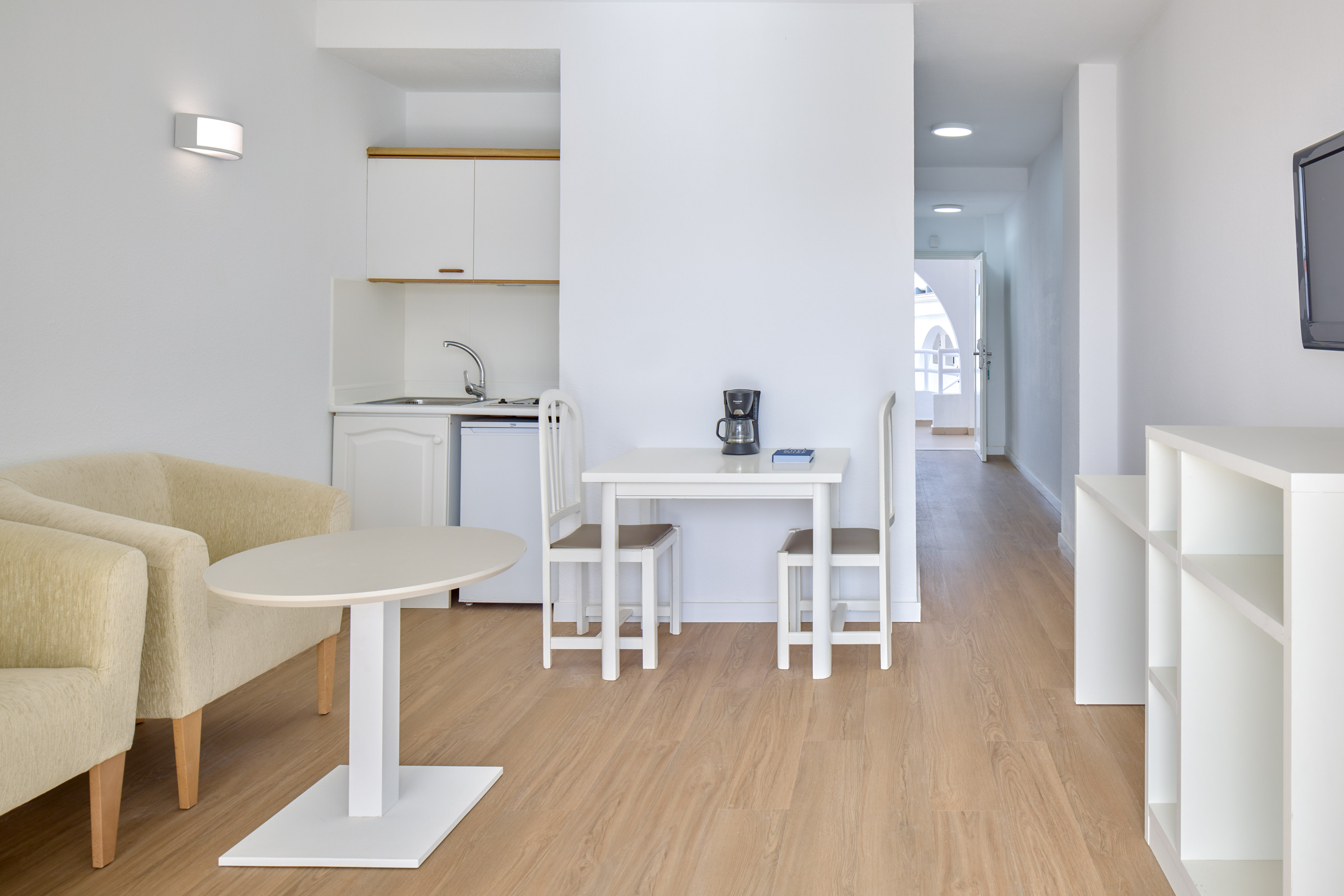 Bright studio apartment with kitchenette, dining table, and living area.