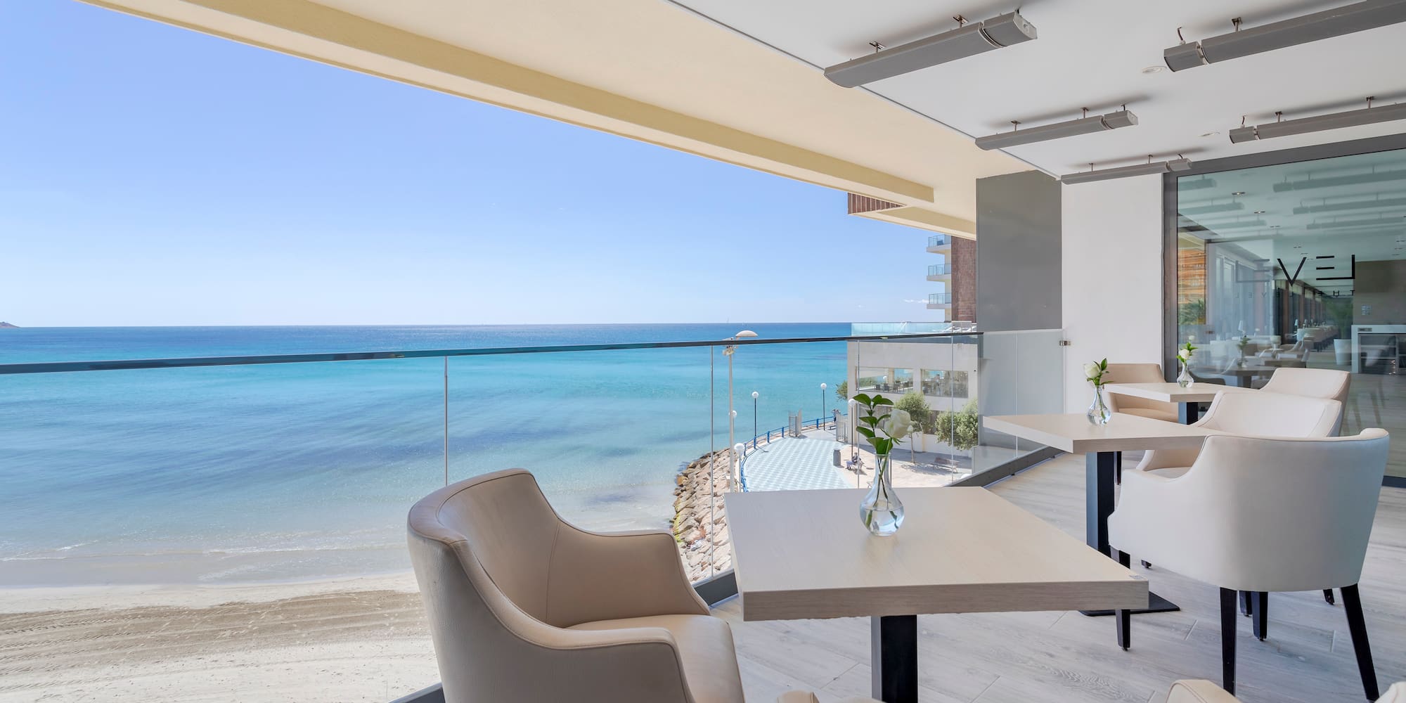 a room with chairs and tables on a beach