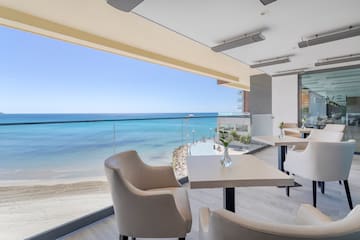a room with chairs and tables on a beach