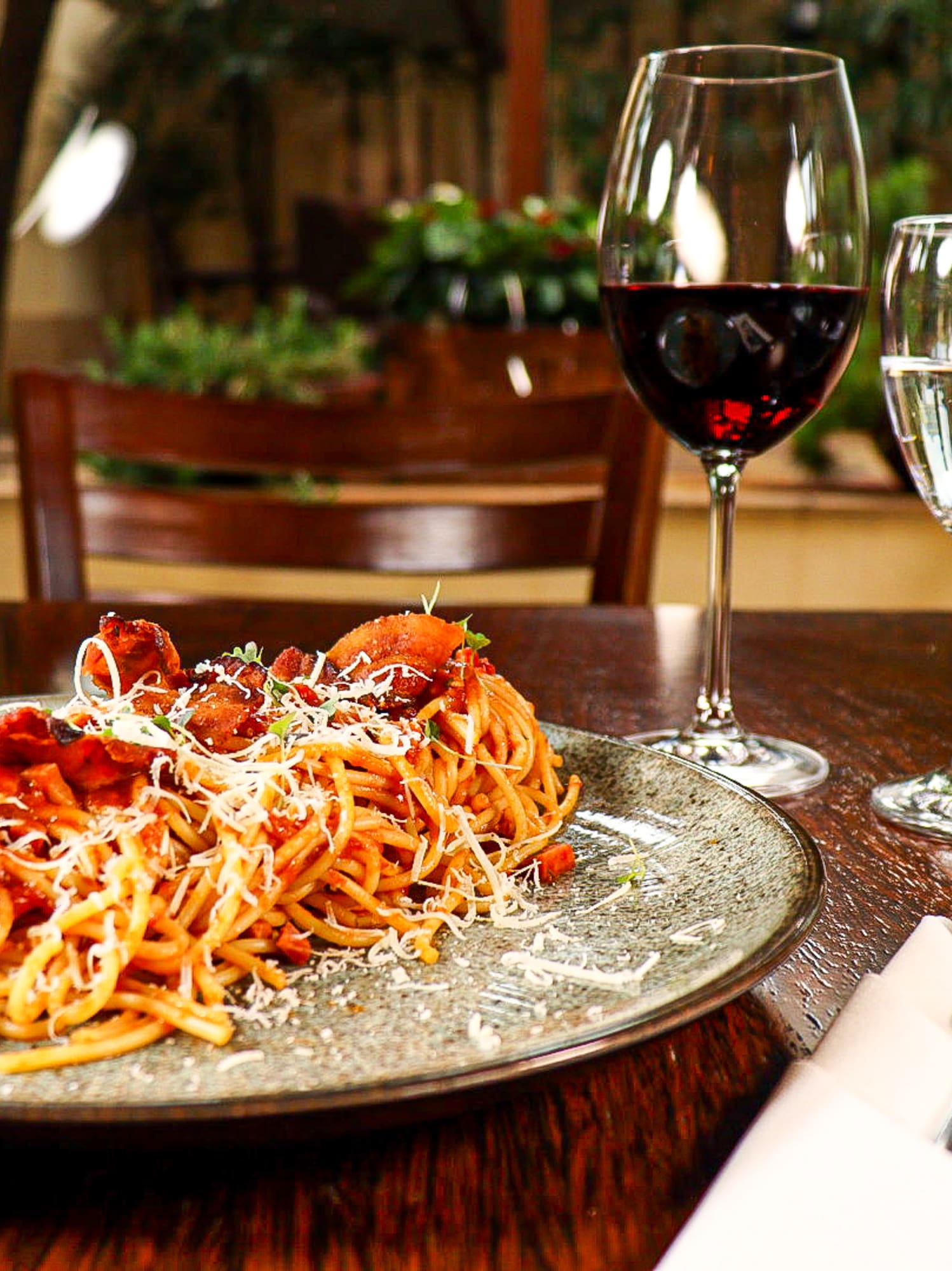 a plate of pasta and wine glasses on a table