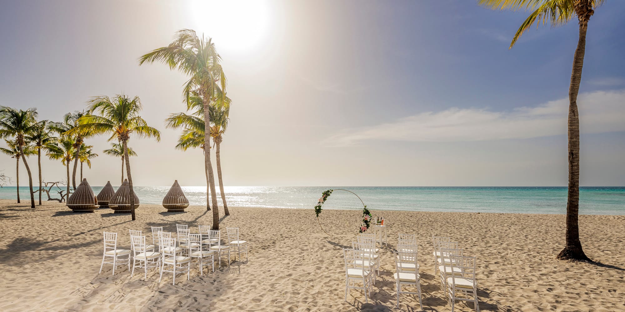 a beach with chairs and palm trees