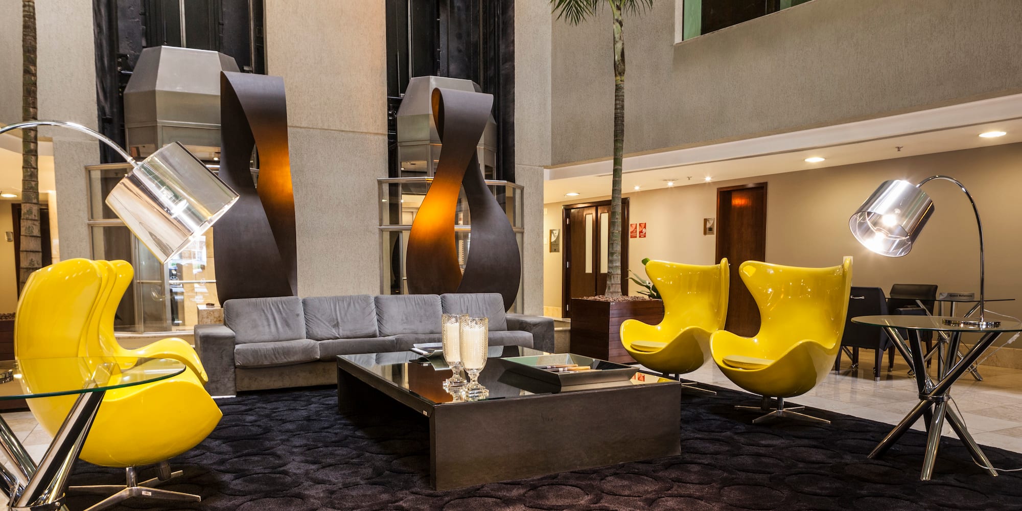 a room with a couch and yellow chairs