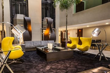 a room with a couch and yellow chairs