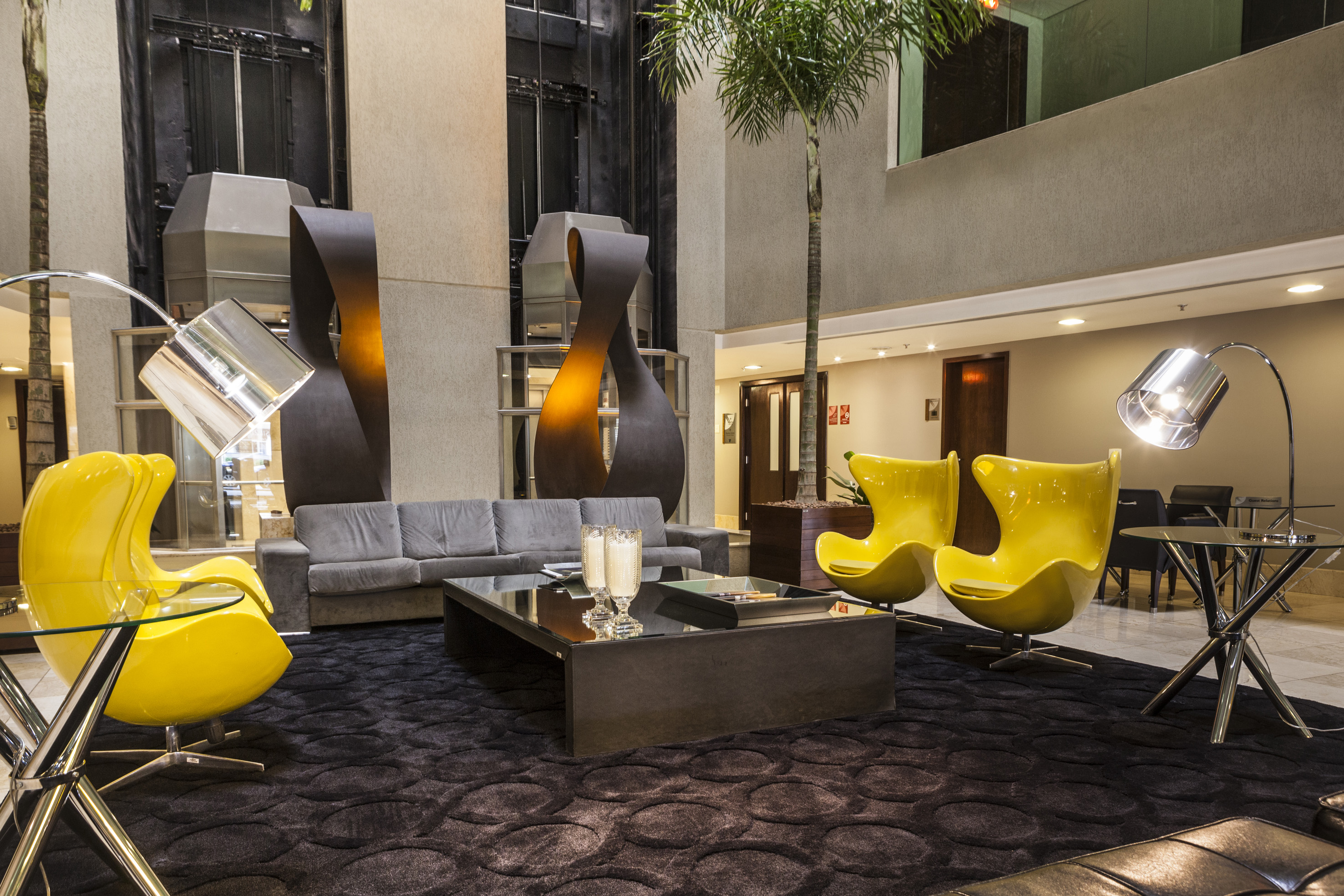 a room with a couch and yellow chairs