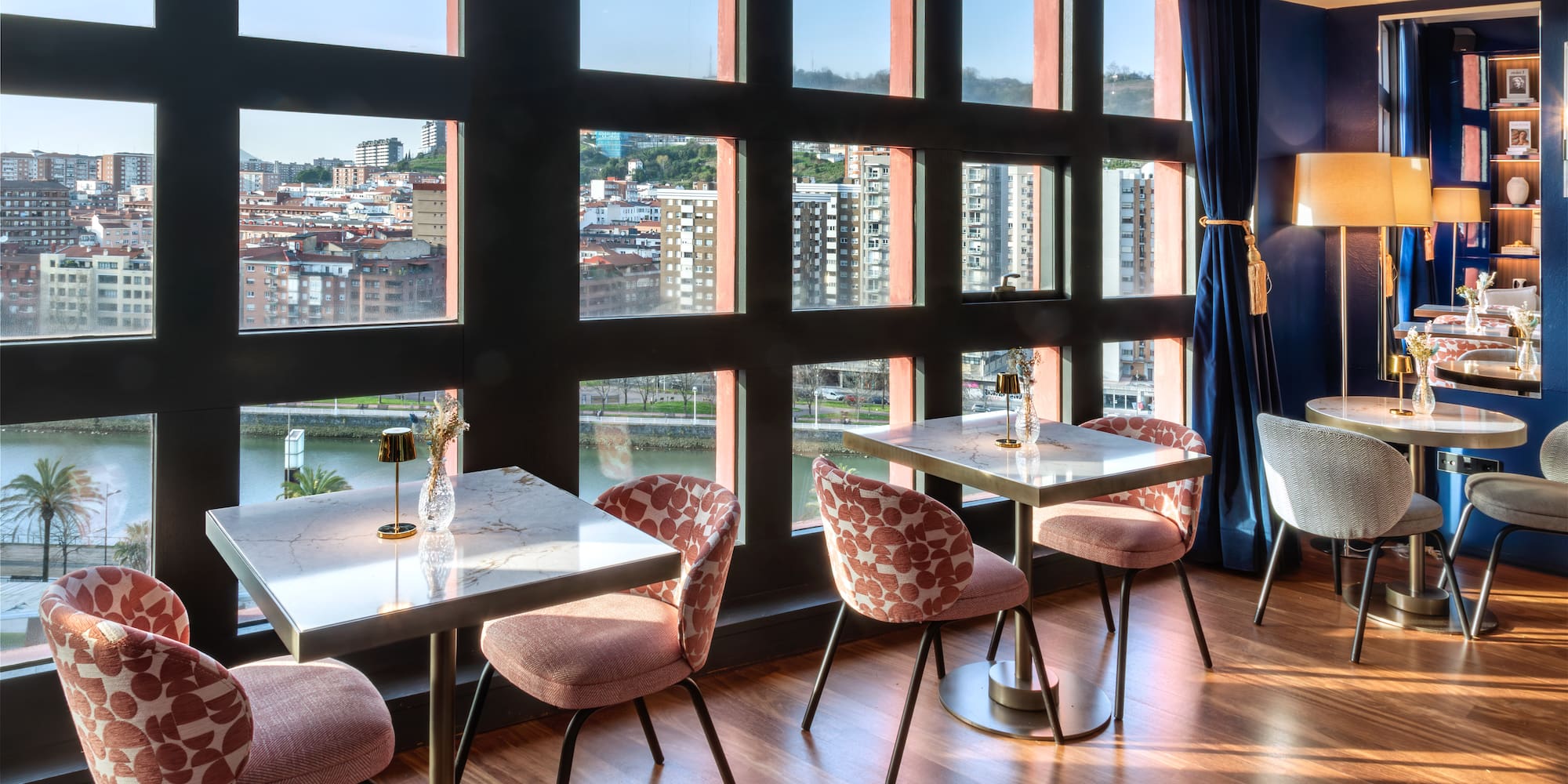 a room with tables and chairs and a view of a city