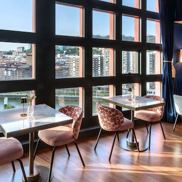 a room with tables and chairs and a view of a city