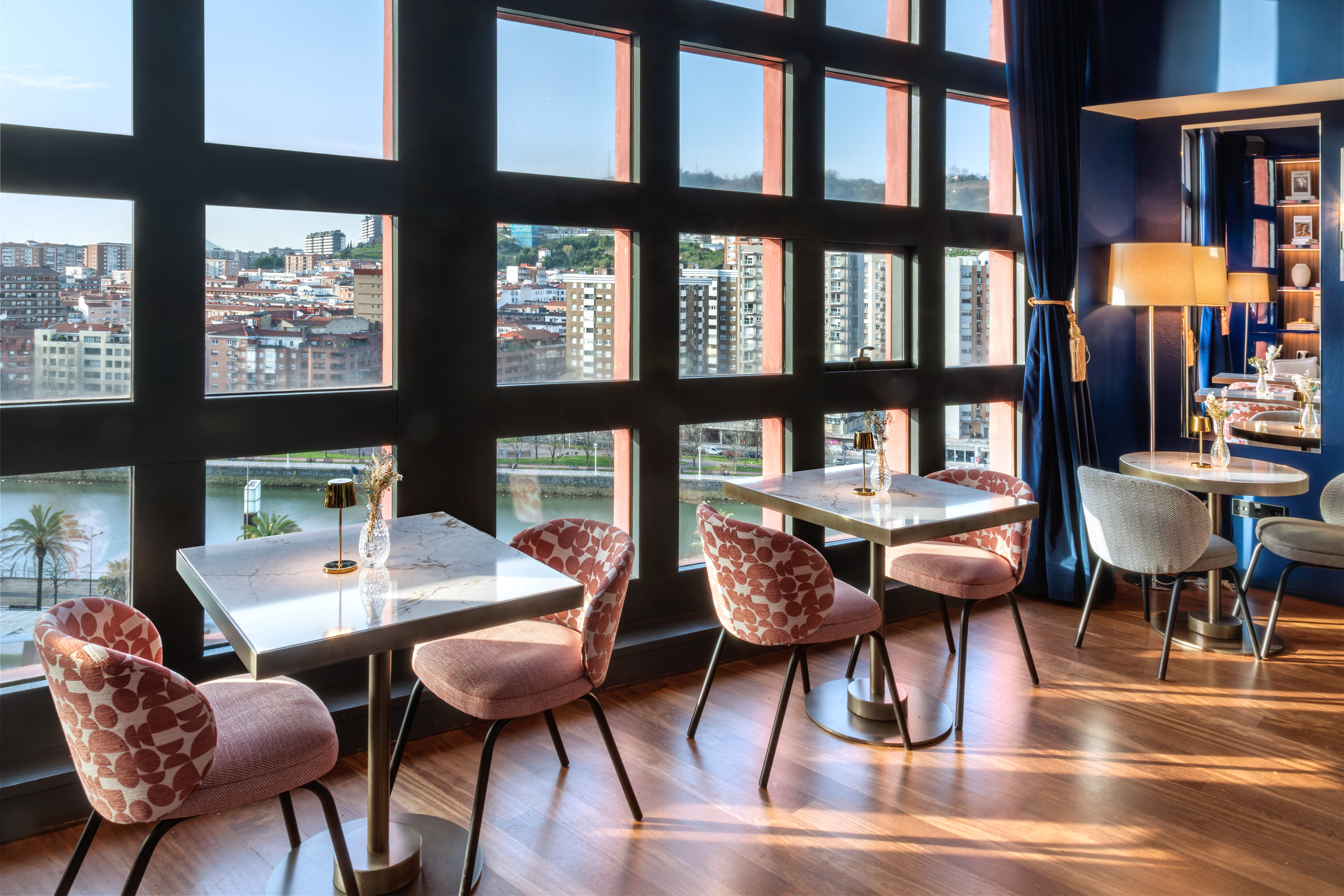 a room with tables and chairs and a view of a city