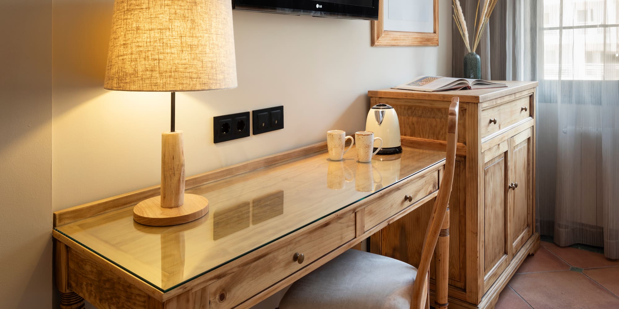 a desk with a lamp and a chair in a room