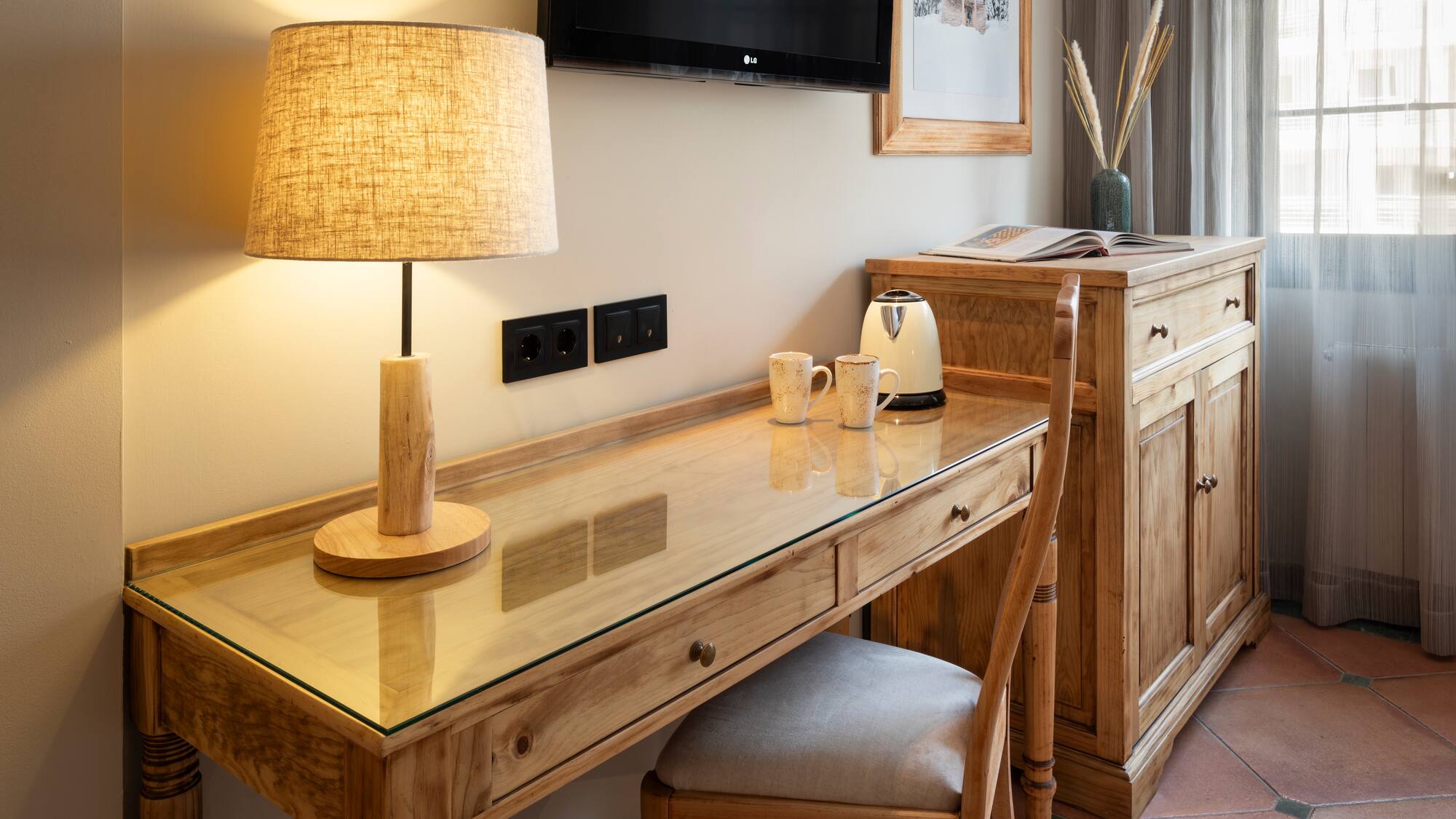 a desk with a lamp and a chair in a room