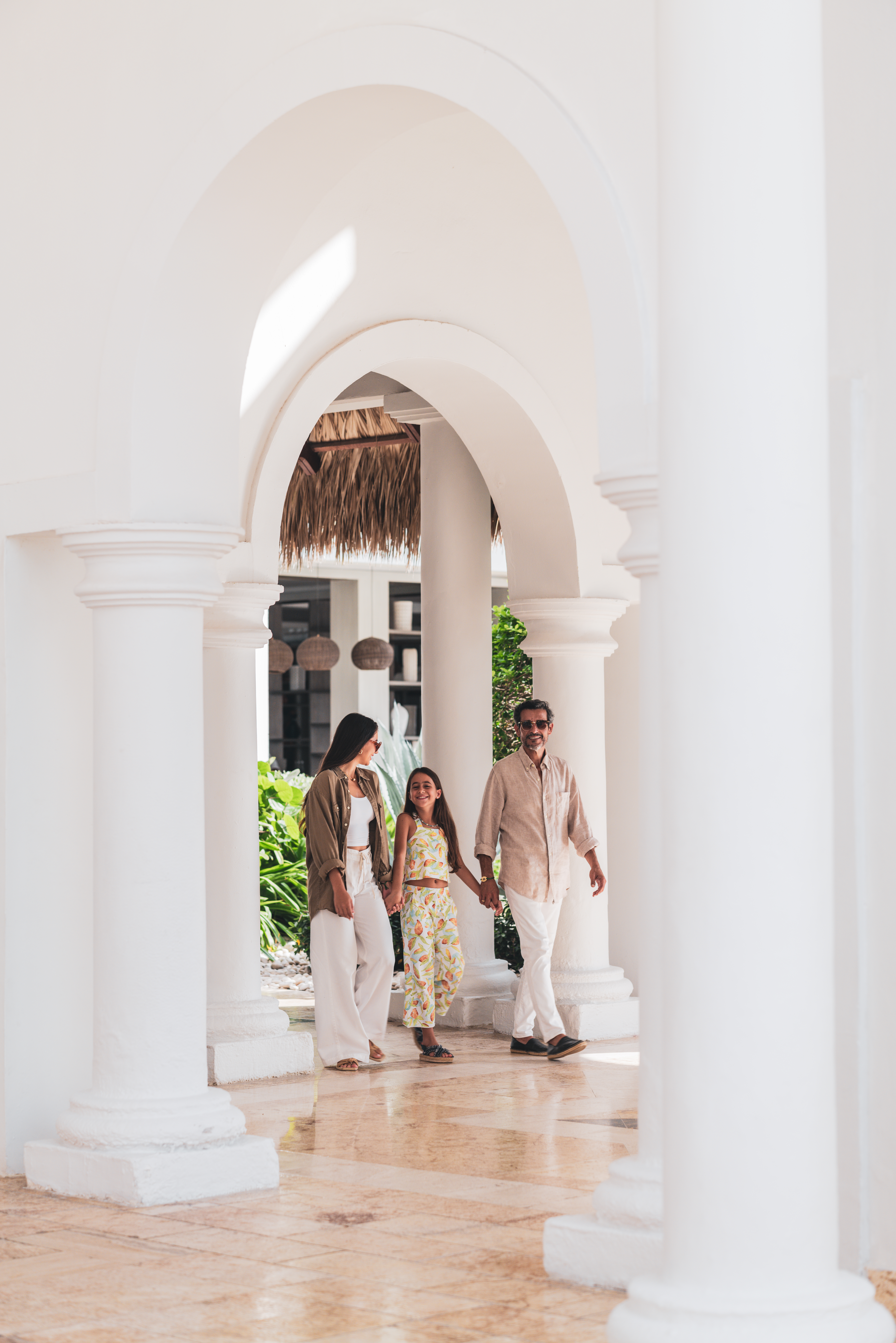 a man and woman holding hands and walking in a white building