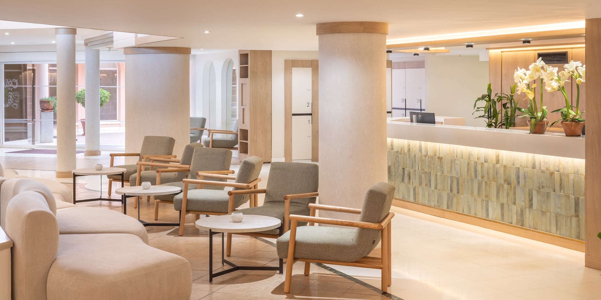 Modern hotel lobby with reception, comfortable seating, and elegant decor.