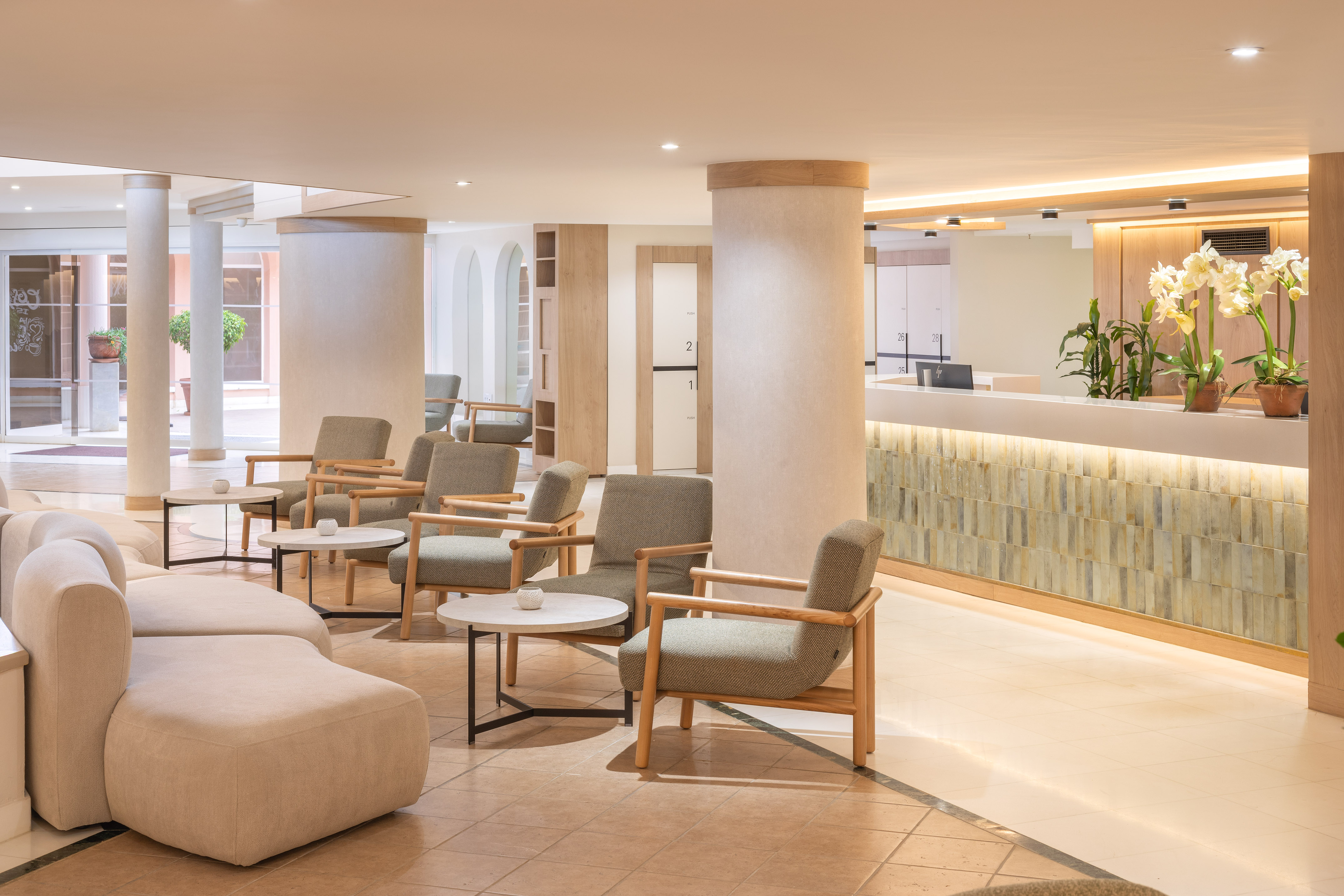 Modern hotel lobby with reception, comfortable seating, and elegant decor.