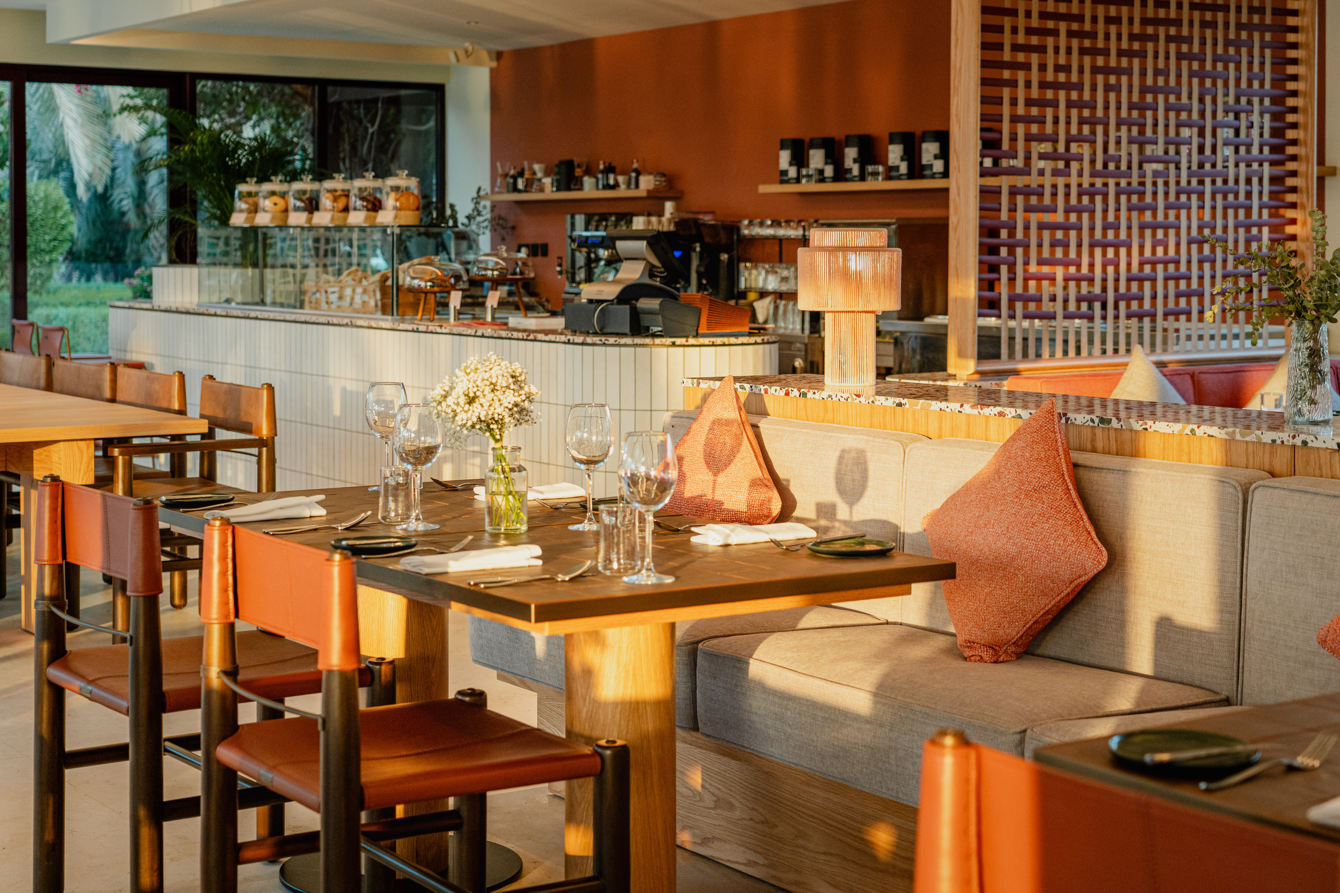 a table with wine glasses and a couch in a restaurant