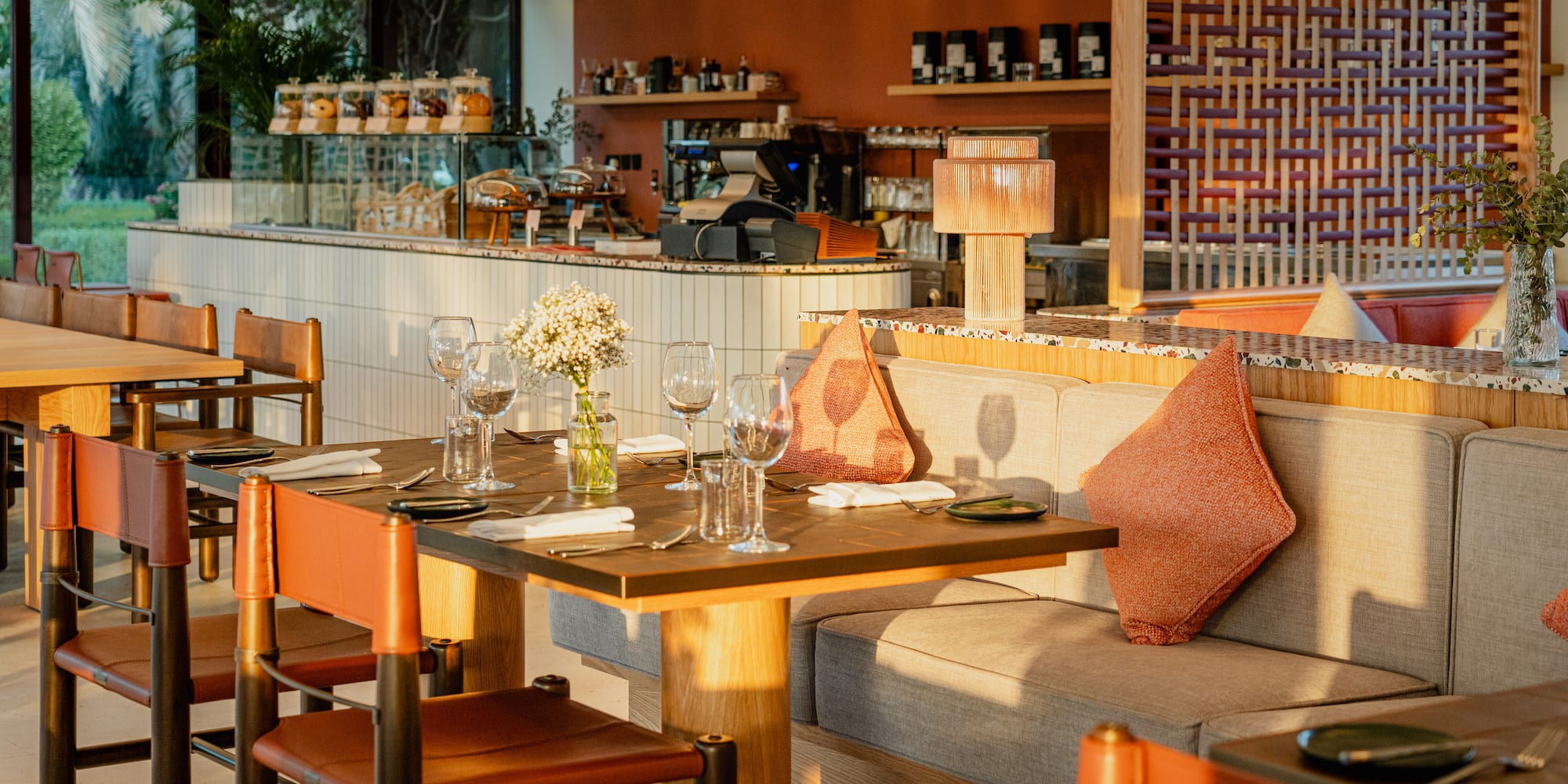 a table with wine glasses and a couch in a restaurant