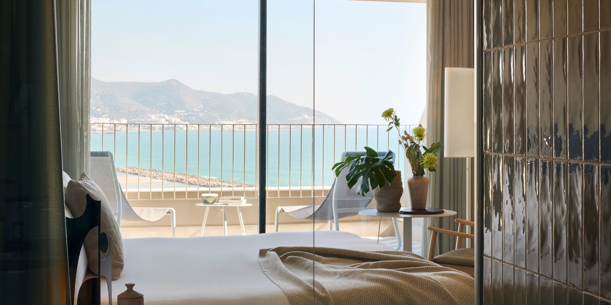 a room with a bed and a view of the ocean