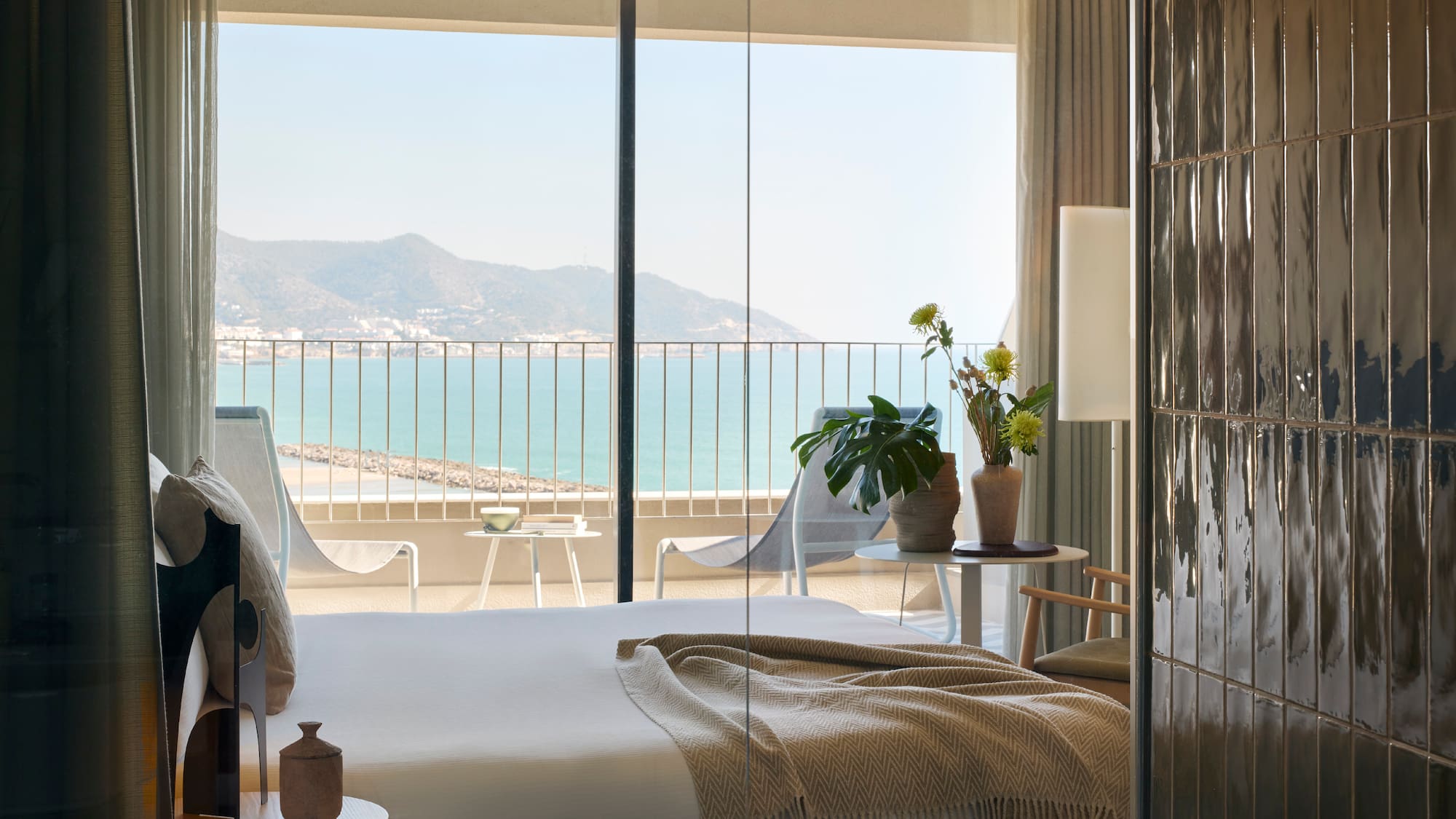 a room with a bed and a view of the ocean