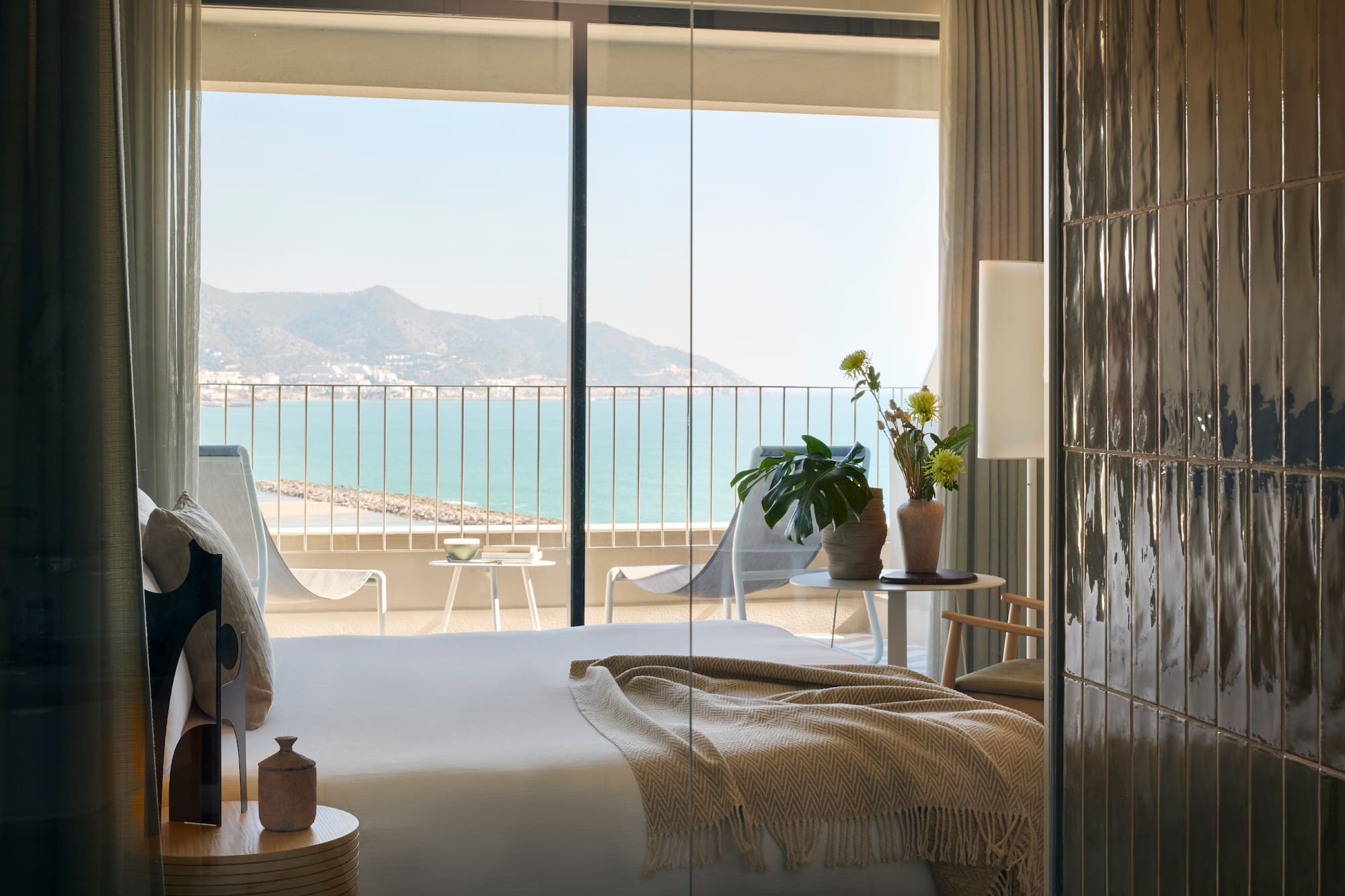 a room with a bed and a view of the ocean