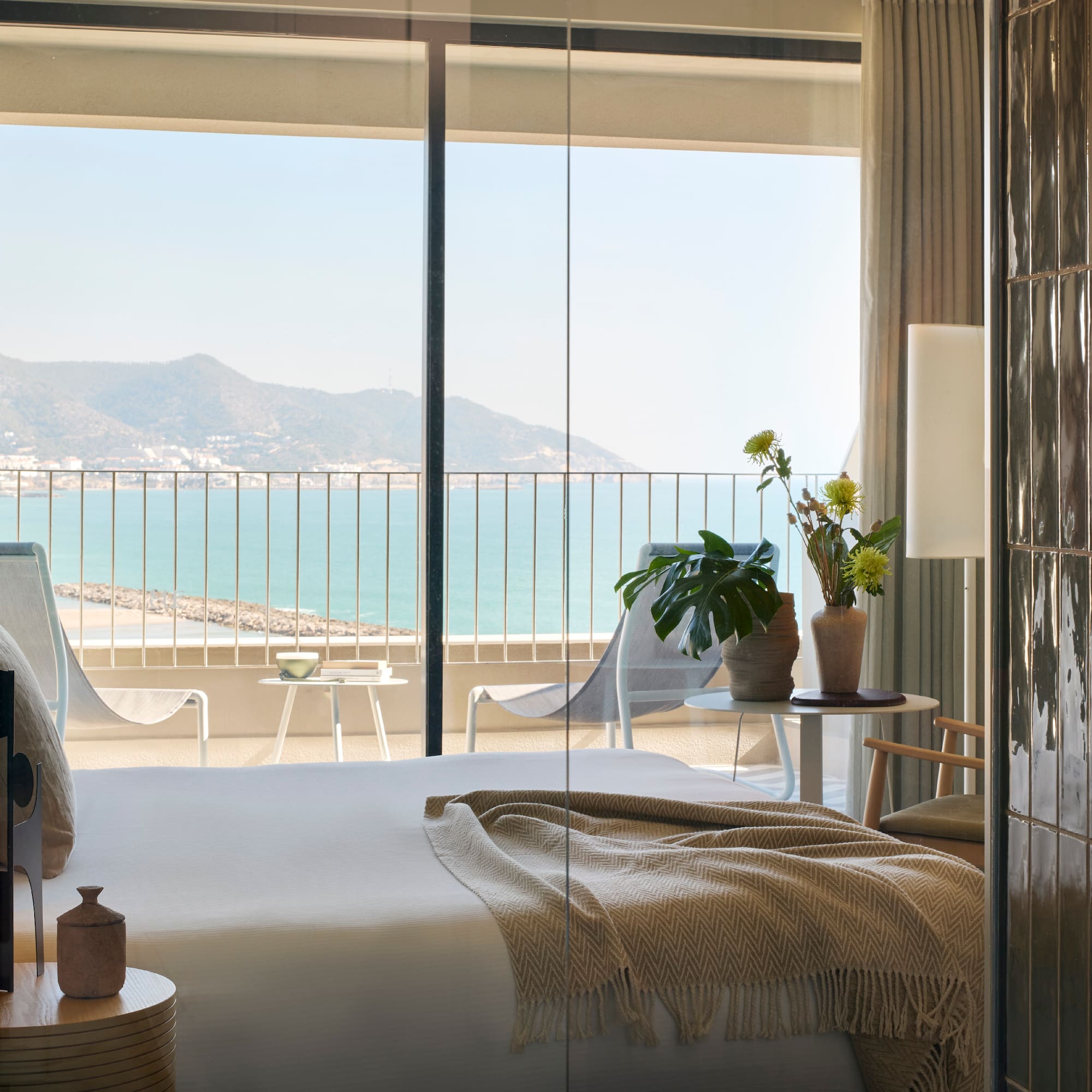 a room with a bed and a view of the ocean