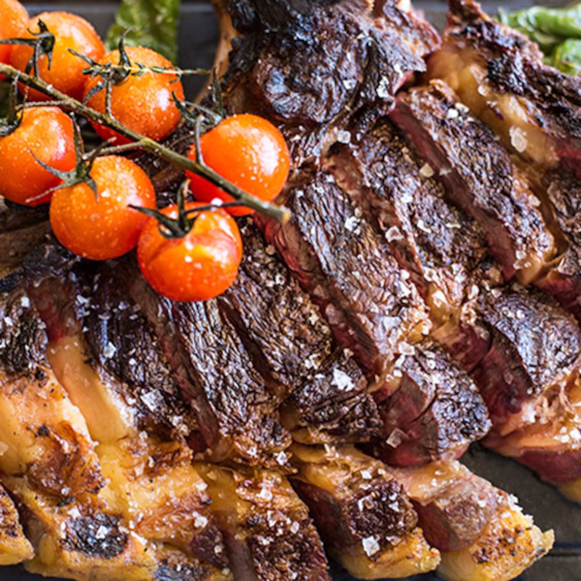 a piece of meat with tomatoes on top