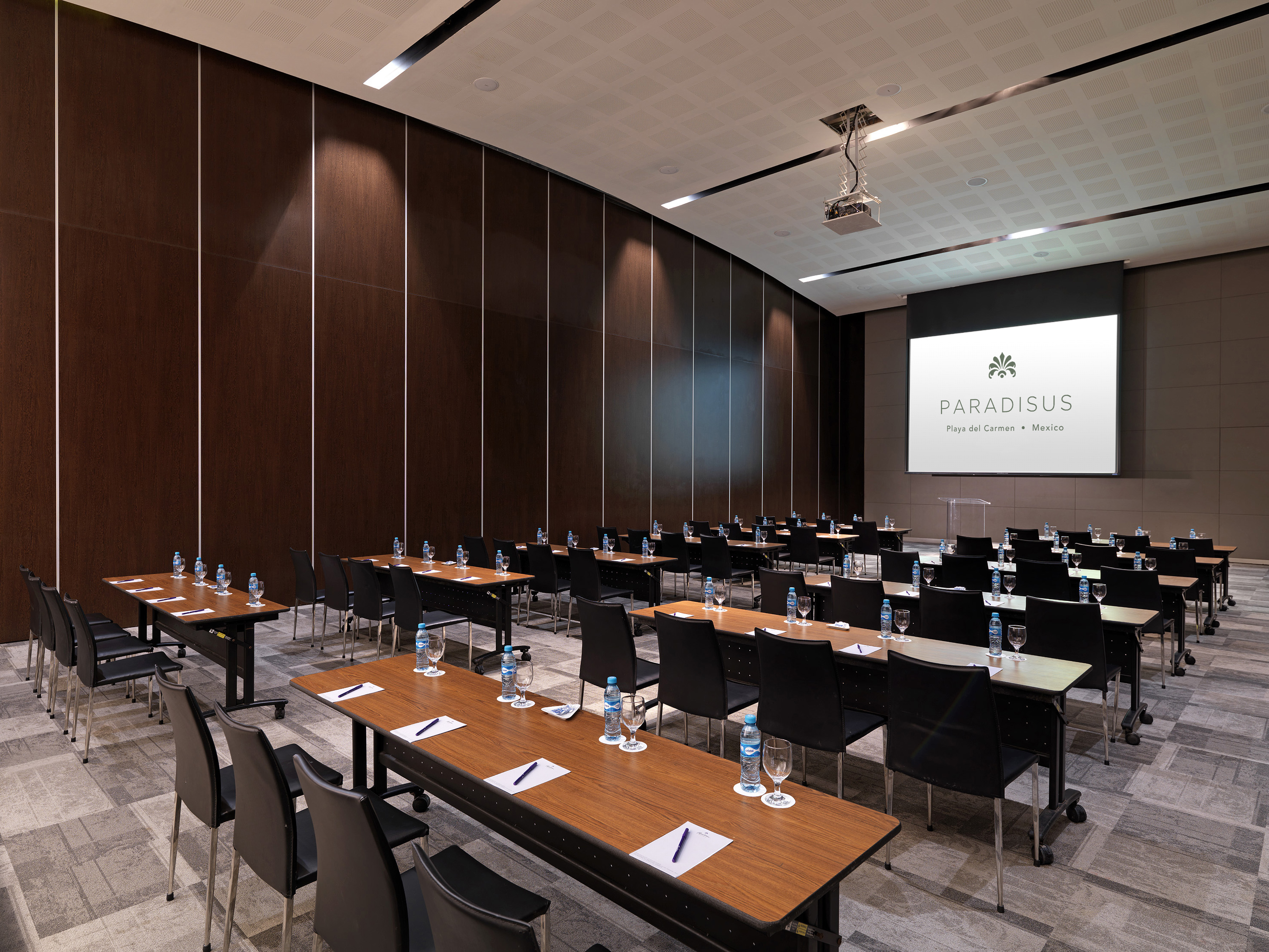 Paradisus Playa del Carmen meeting room setup with rows of tables and screen.