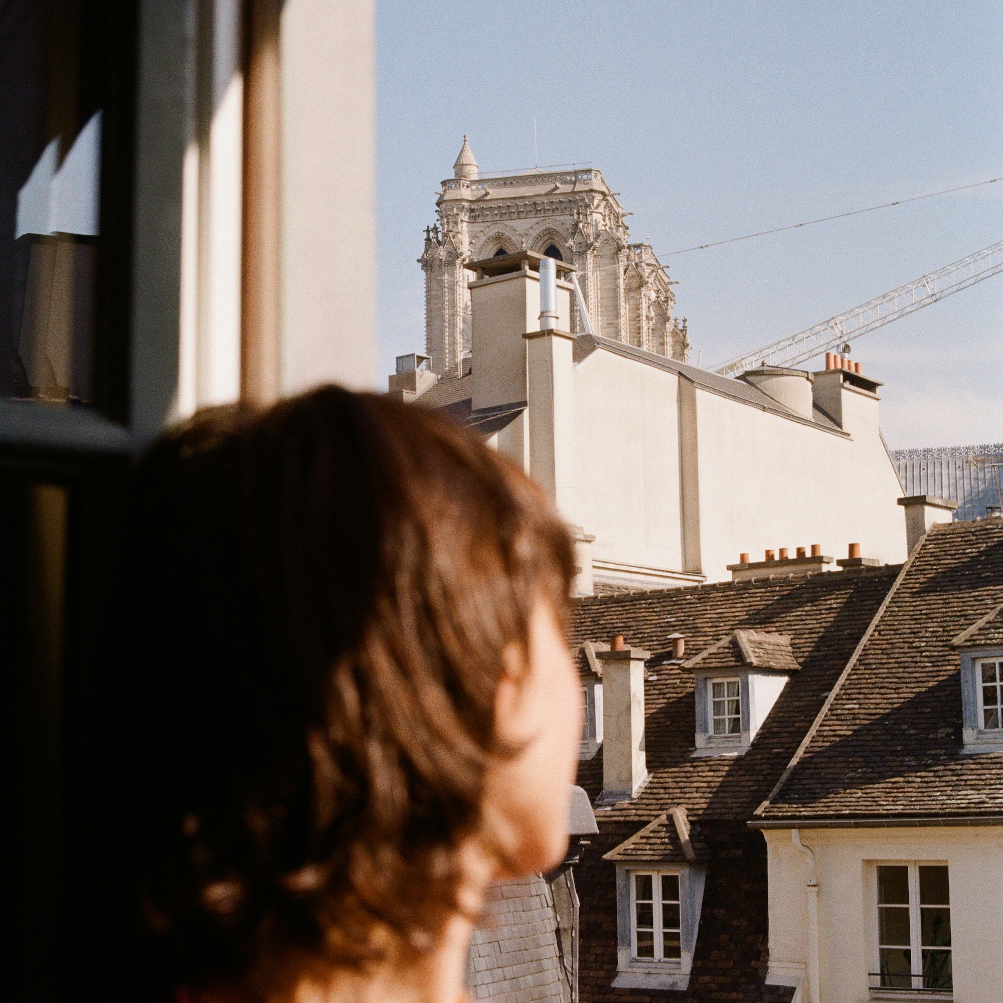 a person looking out a window at a building