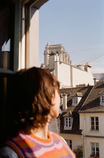 a person looking out a window at a building