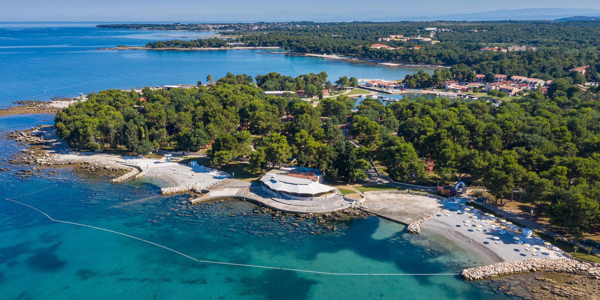 an aerial view of a beach with trees and water