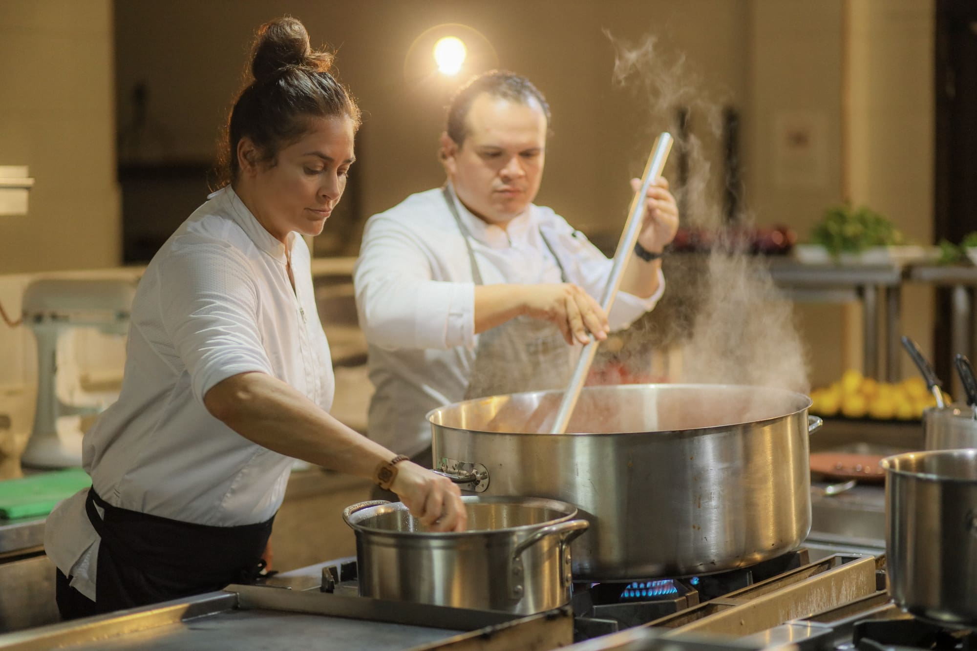 a man and woman cooking in a kitchen