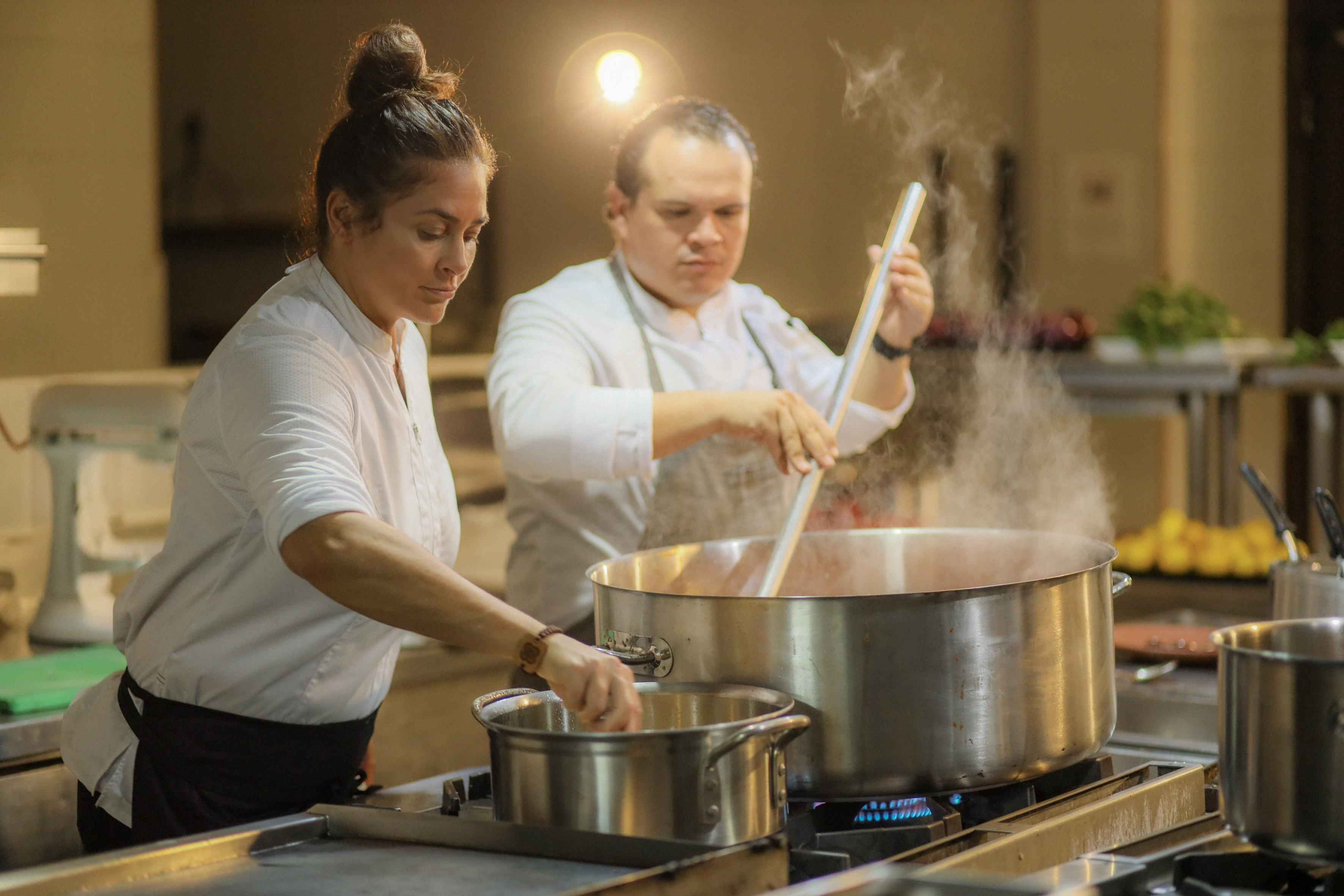 a man and woman cooking in a kitchen