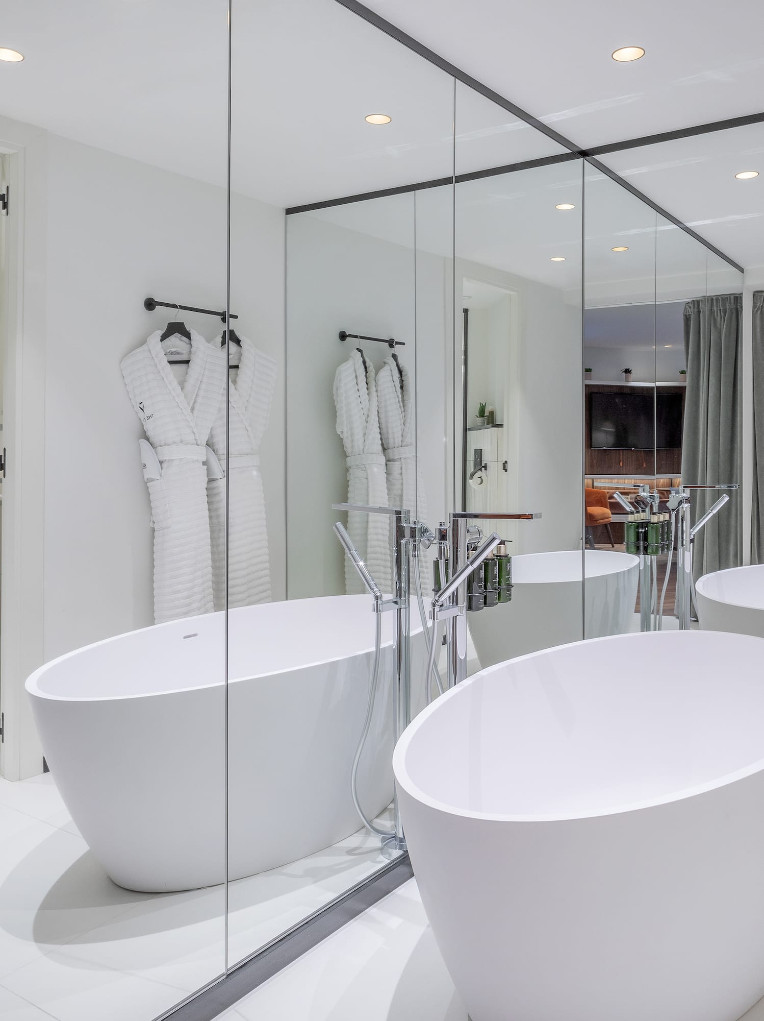 a bathroom with large tubs and mirrors
