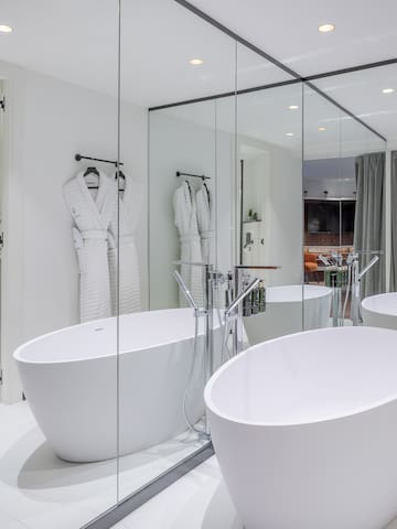 a bathroom with large tubs and mirrors